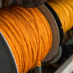 Spools of yellow polyethylene nylon ropes for sale at a fishing supply store.